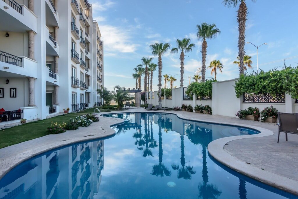 Los Cabos Puerta Cabos Village This lovely two bedroom and two bath condo is close to everything. It's just a short walk to Medano Beach, town center, shopping, the marina and entertainment. The primary bedroom has an ensuite bathroom with bath tub. The ground floor position means that you are just steps from the heated pool in the lush green common area. Sub terranean parking with a private storage area. This property is an excellent value, offered fully furnished. Great rental potential. – Casa de la Alegria, Cabo San Lucas, BS